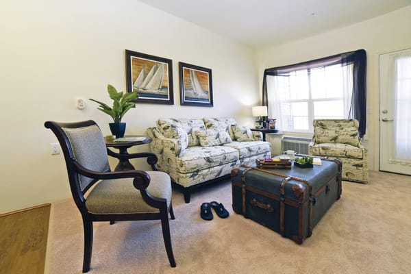 A cozy living room setup with floral sofas and a trunk coffee table.