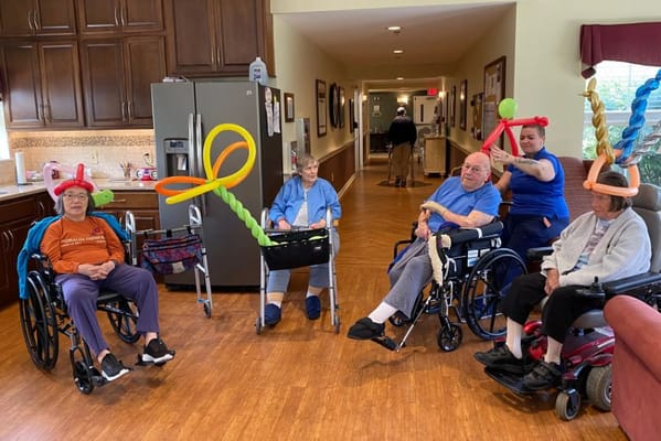 Residents enjoying a balloon activity in the activity room