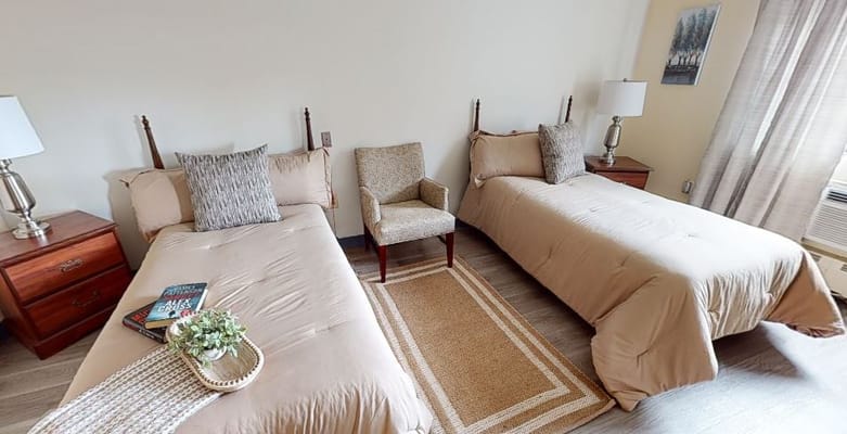 Cozy shared resident room with twin beds and seating area