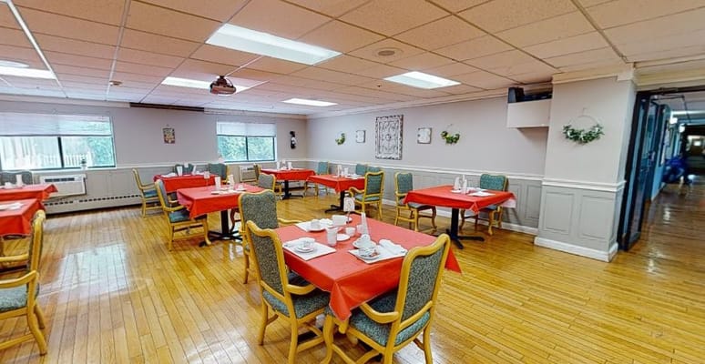 Bright dining room with red tablecloths and seating