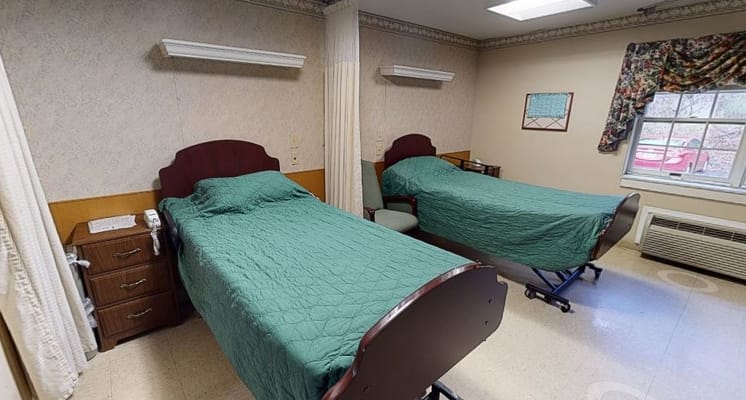 A shared resident room with two beds and furniture