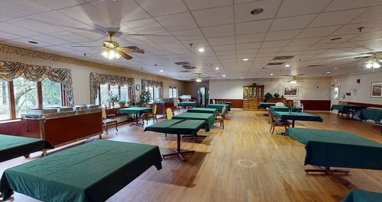 Empty dining room with tables covered in green cloths