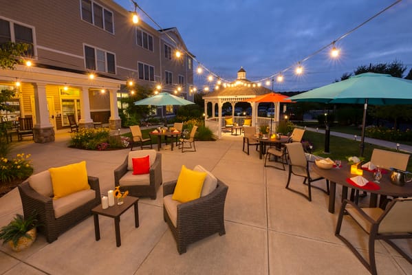 Patio area with seating, gazebos, and string lights at night