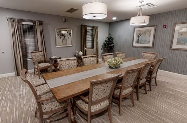 Cozy dining room with a long wooden table and patterned chairs.