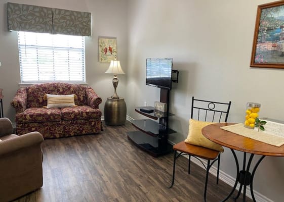 Comfortable living room with a sofa, television, and dining table