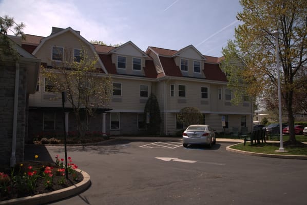 Exterior view of the assisted living facility surrounded by gardens