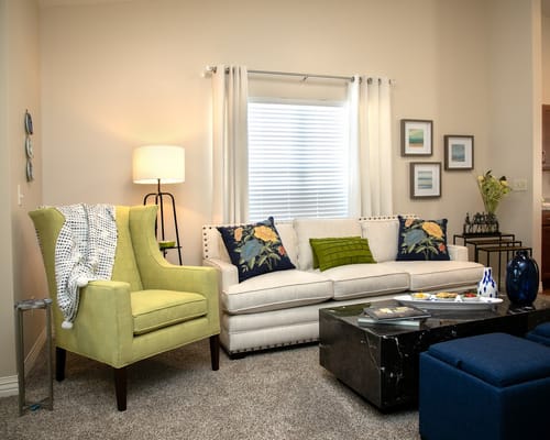 Bright and inviting living room with a green chair and a white sofa
