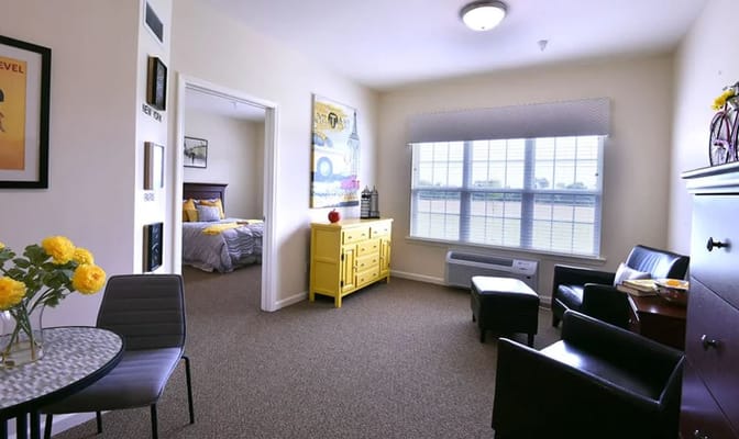 Spacious living room with yellow accent furniture and large windows.