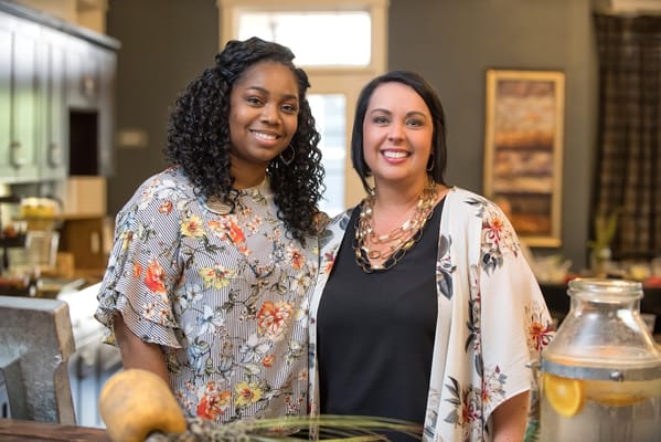 Two staff members smiling in a common area