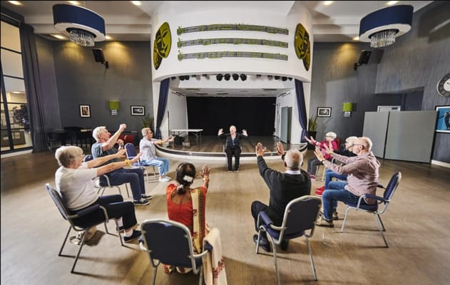 Seniors participating in an exercise class in a community hall.