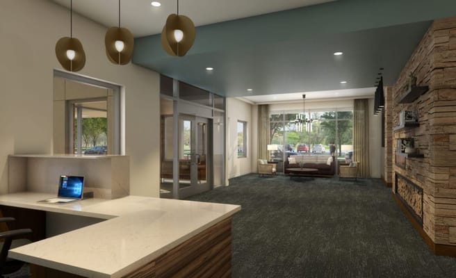 Modern lobby with a reception desk and seating area.