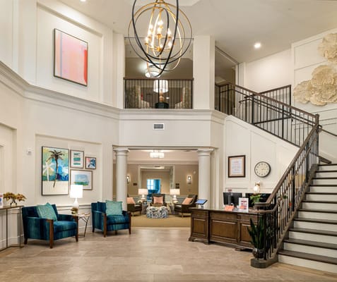 Bright and spacious lobby area with seating and a staircase