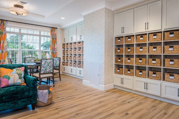 Bright common area with a green couch, dining table, and storage units