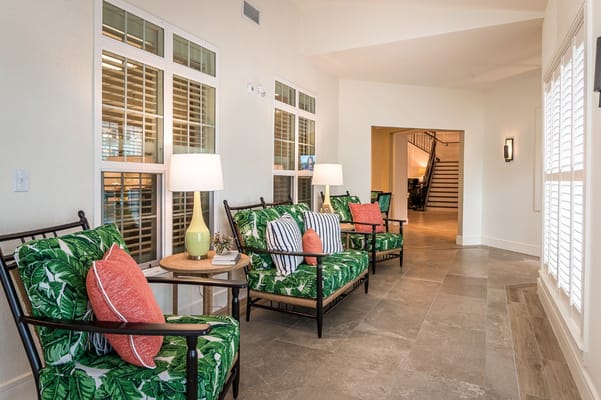 Comfortable lounge area with green and striped seating, lamps, and a side table