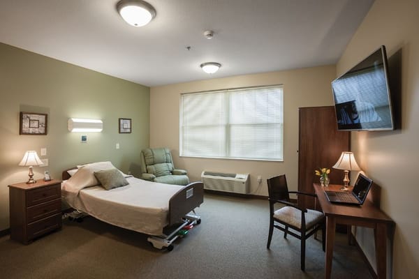 Cozy resident room with a bed and recliner