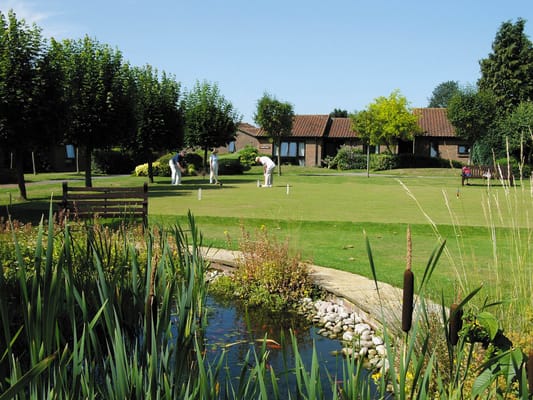 Residents playing croquet in a grassy outdoor area