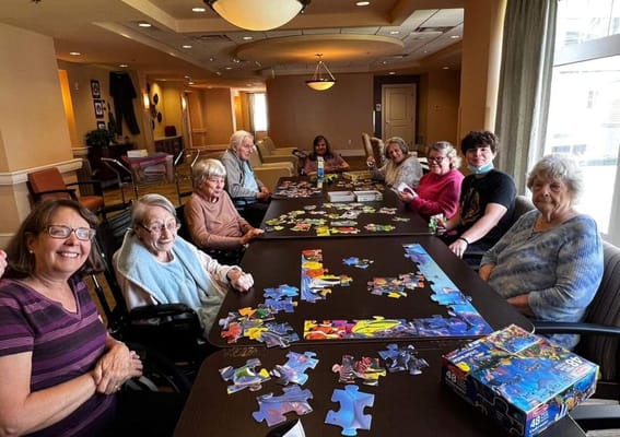 Residents enjoying a puzzle activity in the common area