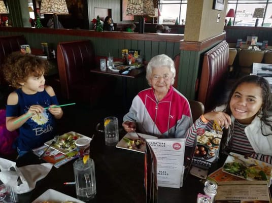 A senior resident enjoying a meal with children