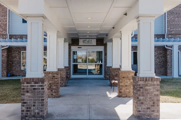 Main entrance of English Meadows with columns and doors