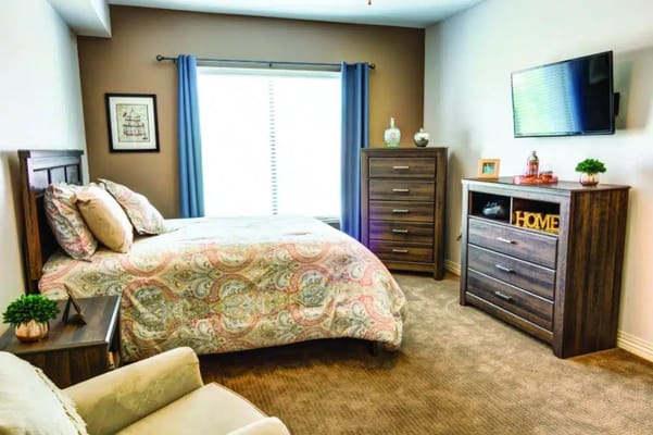 Cozy bedroom with a bed, dresser, and TV