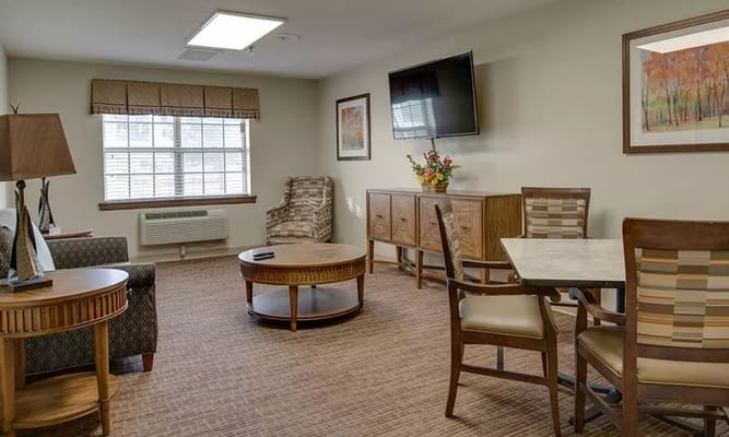 Cozy living room with seating, coffee table, and TV.