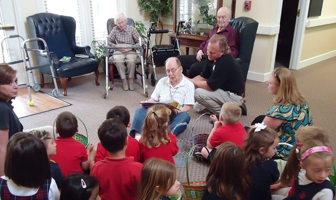 Residents and children engaging in a reading activity