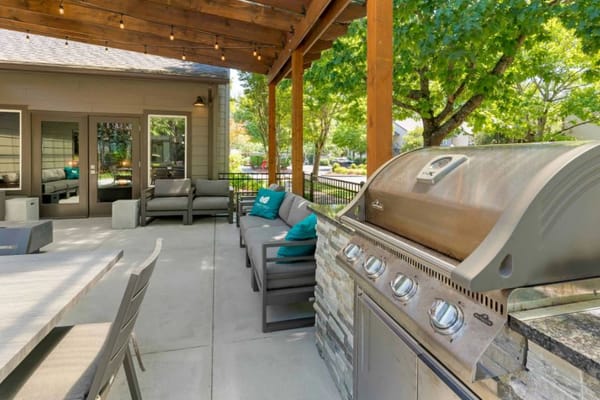 Outdoor seating area with grill and greenery