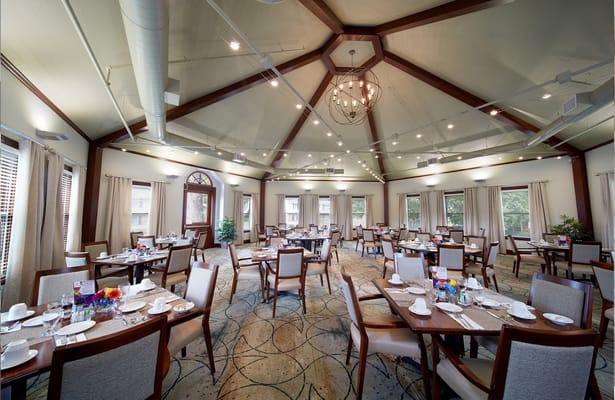 Brightly lit dining room with tables set for meals
