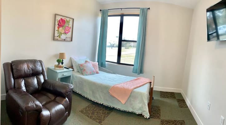 Cozy resident bedroom with chair and window view