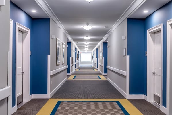 Brightly lit interior hallway of a senior living facility