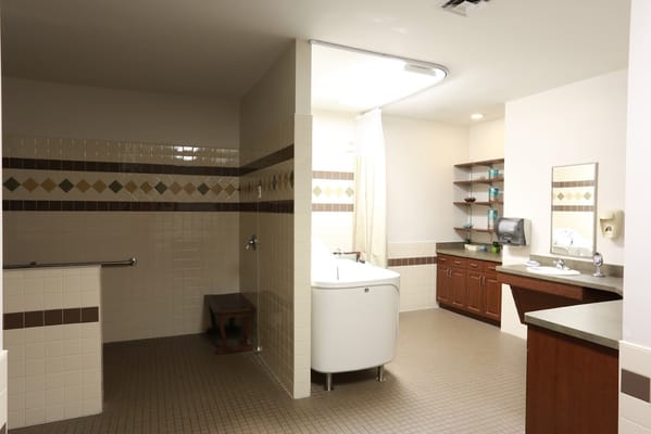 Bright and spacious accessible bathroom with tub and sink.