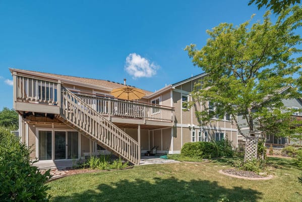 Backyard area with a deck and umbrella at Gardens Care Senior Living.