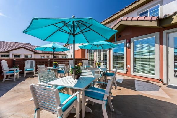 Brightly colored outdoor seating area with turquoise umbrellas and tables