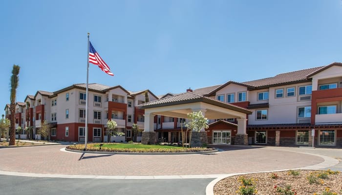 Front entrance view of Gardens at Ocotillo with American flag.