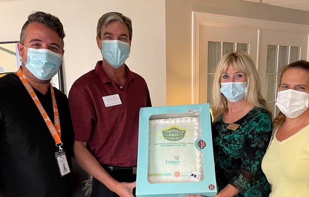 Staff celebrating with a cake in a common area