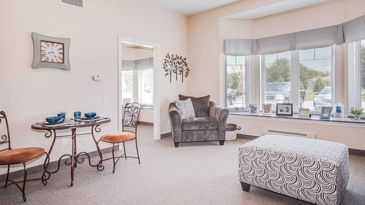 Living room with a table, chairs, and natural light.