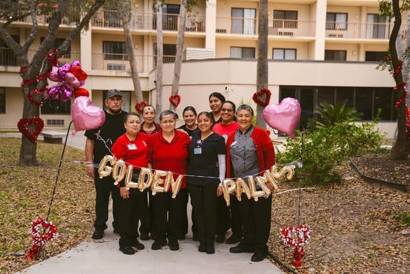 Staff celebrating with a banner in the courtyard