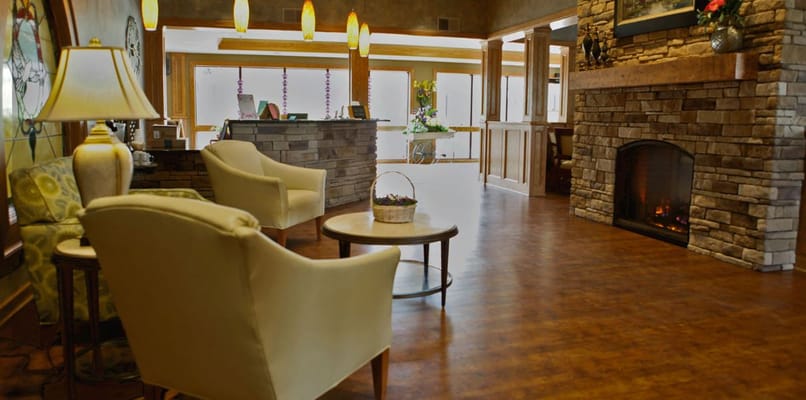 Cozy lobby with armchairs, a fireplace, and front desk