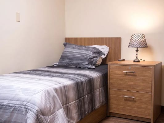 Bedroom with a bed, bedside table, and lamp.
