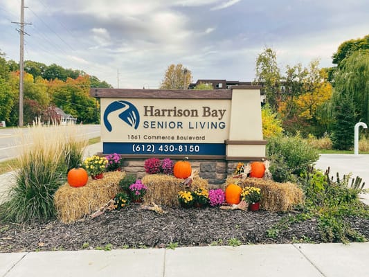 Exterior sign of Harrison Bay Senior Living with fall decorations