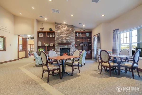 Common area with tables and a stone fireplace