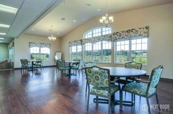 Bright common area with round tables and floral chairs