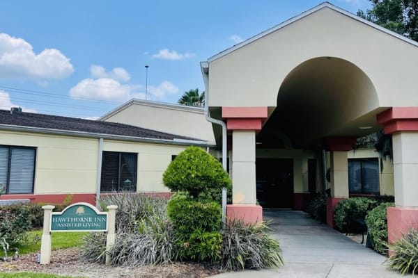 Entrance of Hawthorne Inn assisted living facility with sign and landscaping