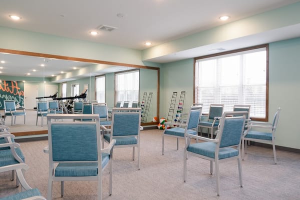 Bright exercise room with seating and fitness equipment