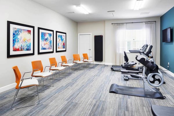 Interior fitness room with exercise equipment and seating