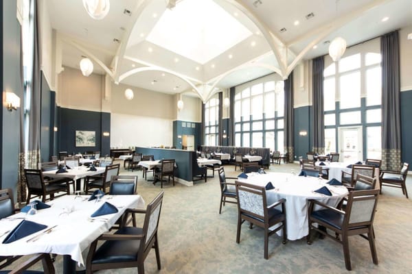 Elegant dining room setup with tables and chairs.