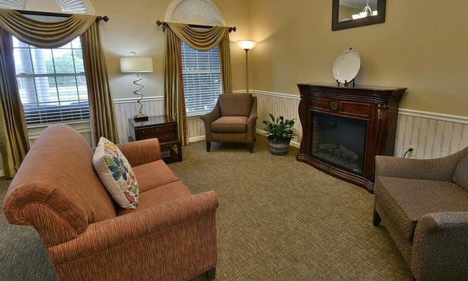 A cozy living room with a fireplace and seating area