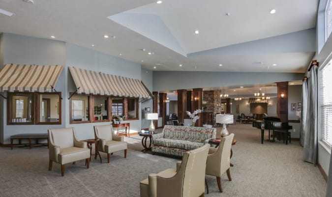 Spacious living room with armchairs and a floral sofa at Heritage Hill Assisted Living.