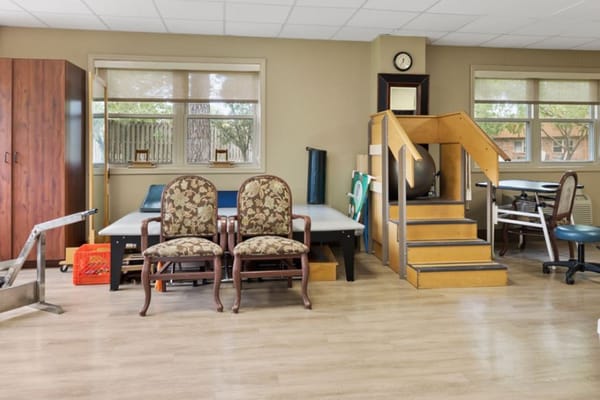 Interior view of a therapy room with chairs, stairs, and equipment