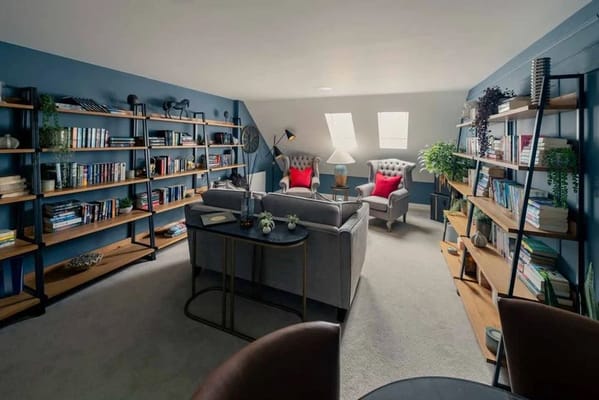Lounge with bookshelves, chic seating, and a cozy atmosphere